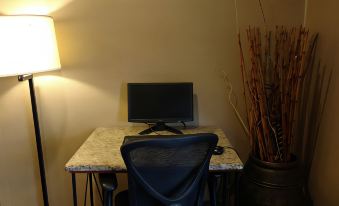 a black computer monitor is placed on a desk with a chair in front of it at Quality Inn Denver Northeast Brighton