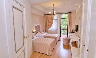 a modern bedroom with wooden floors , white walls , and pink curtains , featuring two beds , a desk , and a window at Aspen Hotel