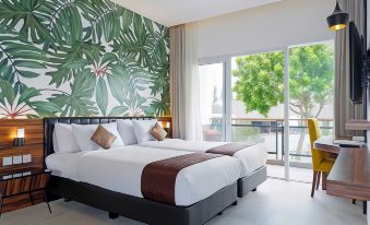 a modern hotel room with two beds , a large window offering a view of palm trees , and tropical wallpaper on the wall at Front One Resort Magelang