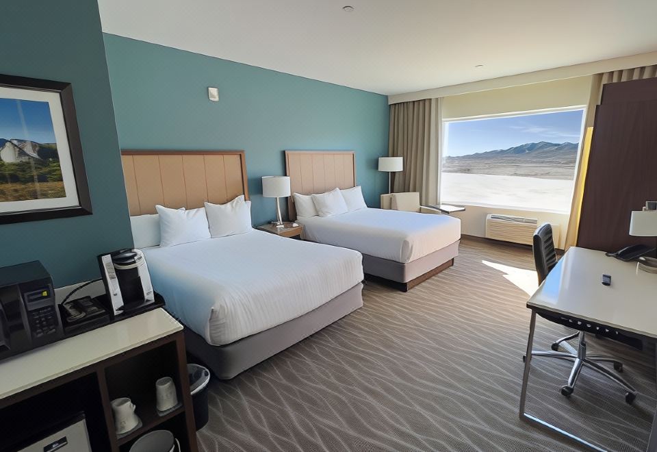 a hotel room with two beds , a desk , and a window , all decorated in a modern style at Cahuilla Casino Hotel
