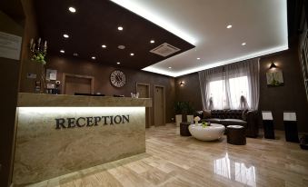 "a modern reception area with a large clock , a desk , and a sign reading "" reception "" on the wall" at Royal Airport Hotel