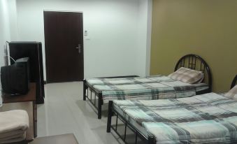 a room with two beds , one on the left side and another on the right side at Thanarom Place