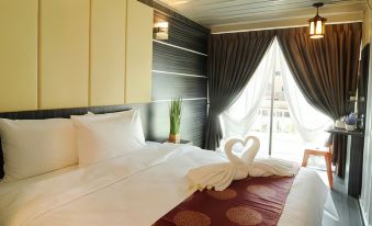 a clean , well - organized bedroom with a white bed and a large window overlooking the city at Ppt Muar Hotel