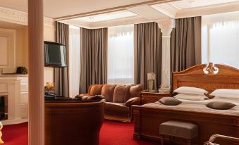 a hotel room with a large bed , couch , and a tv . also a bathroom visible in the room at Hotel Europe