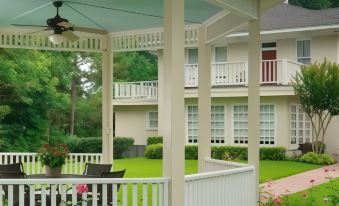 a beautiful garden with a gazebo and a dining table , surrounded by lush greenery and flowers at Delta Street Inn