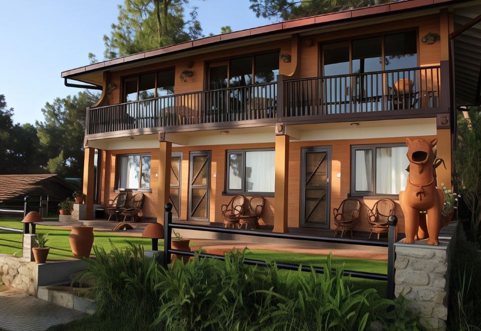 The house features balconies and windows on the side, accompanied by outdoor seating at Haatiban Resort