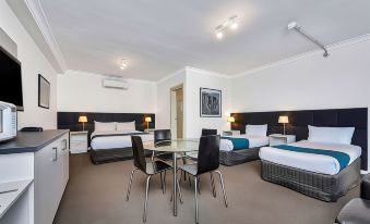 a modern hotel room with two beds , a dining table , and chairs , as well as a balcony at Comfort Inn & Suites Manhattan