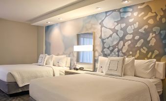 a hotel room with two beds , one on the left side and the other on the right side of the room at Courtyard Philadelphia Bensalem