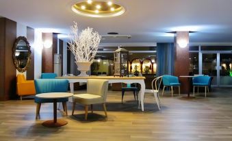 a modern dining room with wooden flooring , white table and chairs , and blue accents , as well as a large window providing natural light at Hotel Miami