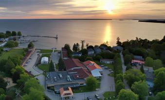 a bird 's eye view of a coastal town with houses , trees , and a sunset over the water at Ramada by Wyndham Jacksons Point