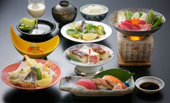 a dining table filled with a variety of food items , including sushi , salad , and other dishes at Jukeiso