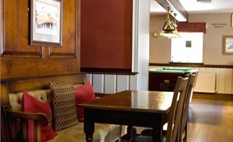a dining room with a pool table in the background and a couch in the foreground at Black Lion Hotel