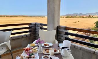 a table set with a variety of food and drinks on a balcony overlooking a desert landscape at Il Tramonto