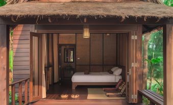 a room with a bed and a sliding door that leads to a bathroom at Azalea Village