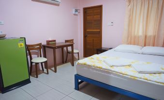 a pink bedroom with a bed , desk , and chairs , as well as a door leading to another room at Lam-Tong Resort