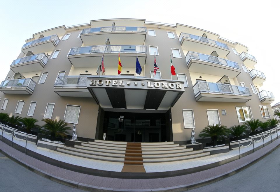 "a large building with a sign that says "" ruppert & thomson "" is shown with flags" at Hotel Luxor