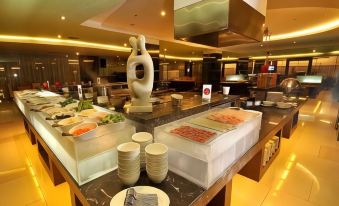 a dining room with a buffet table filled with various food items and utensils , such as knives , forks , and spoons at Golden Flower by Kagum Hotels