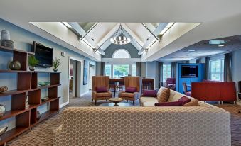 a large living room with multiple couches and chairs arranged in a seating area , creating a comfortable and inviting atmosphere at Residence Inn Boston Foxborough