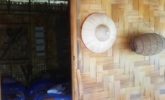 a wooden floor with a ceiling fan hanging from it , and a bed in the background at Peisanae Faikeng Resort