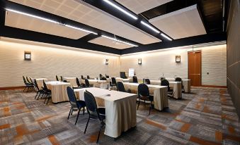 a large conference room with multiple rows of tables and chairs arranged for a meeting at Midgard