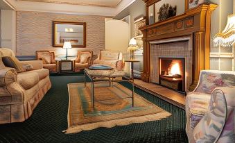 a cozy living room with a fireplace , comfortable furniture , and a rug on the floor at Ees Wyke Country House