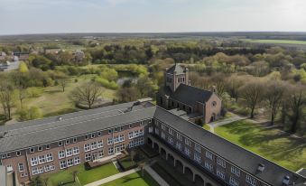 a bird 's eye view of a building with a large courtyard and trees in the background at Fletcher Kloosterhotel Willibrordhaeghe