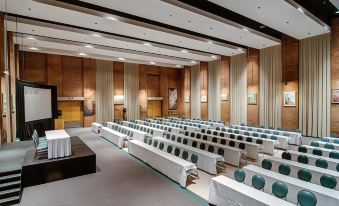 a large conference room with rows of chairs arranged in a semicircle , providing seating for a large group of people at Hotel Moco Valleyfield