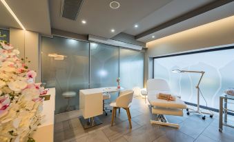 a modern and clean room with white chairs , a desk , and a window , giving it a minimalist and clean appearance at Hotel Pinija