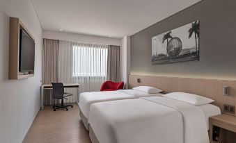 a modern hotel room with two beds , a desk , and a window , decorated with a red chair and white bedding at Park Inn by Radisson North Edsa
