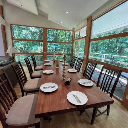 5-Bedroom 6000SF wood and glass retreat in Atlanta, surrounded by greenery.