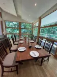 5-Bedroom 6000SF wood and glass retreat in Atlanta, surrounded by greenery.