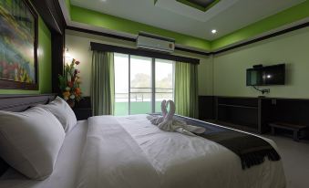 The bedroom features large windows, a white bed, and brown wood paneling on the headboard at Hiso Place Hotel