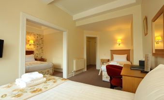 a hotel room with three beds , two of which are on the left side and one on the right side of the room at The Atholl Palace