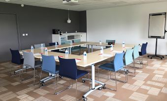 a large conference room with multiple tables and chairs arranged for a meeting or event at Ibis Lyon Villefranche Sur Saone