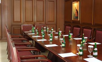 a conference room with a long wooden table , chairs , and several bottles of beer placed on it at Finna Golf & Country Club