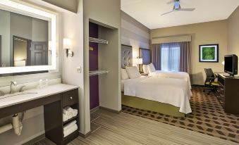 a hotel room with two beds , a desk , and a window , along with a bathroom in the background at Homewood Suites by Hilton Dayton - South/Dayton Mall