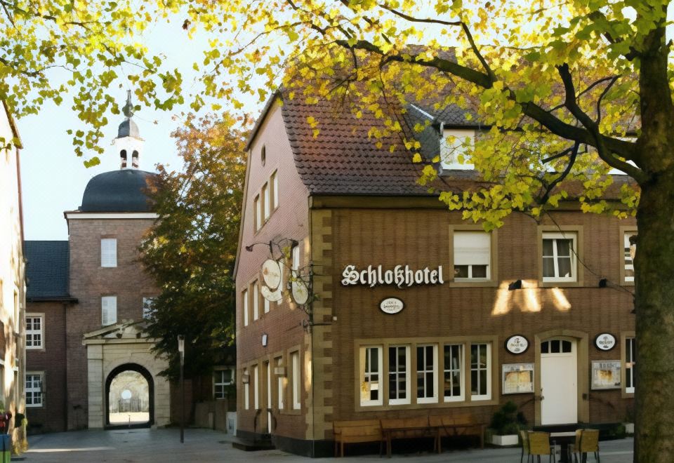 "a building with a sign that reads "" schoelhof hotel "" is shown in the autumn season" at Schlosshotel