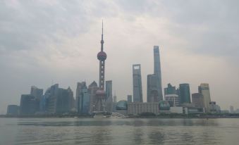 The skyline of skyscrapers and other buildings is visible across the river at Fish Inn (Shanghai East Nanjing Road)