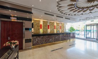 The hotel's lobby features a clean and modern design, highlighted by a spacious reception area adorned with a large marble countertop at Motai Hotel (Shanghai Hongqiao International Exhibition Center Jiuxing)