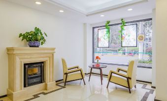 The room features a fireplace with a table and chairs positioned in front of it, creating an inviting and open space at Greentree Inn (Shanghai Jingan)