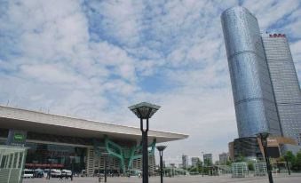 A large building with tall towers and an ornate clock tower in the middle at Rayfont Hotel & Apartment Chengdu