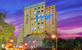 "A large building with a sign that says ""hotel"" in front and another sign" at Nuomo Hotel