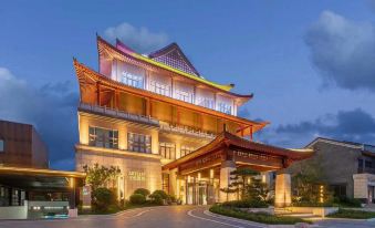a large , modern hotel building with a traditional chinese architectural design and a covered entrance at Artels
