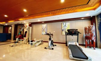 a well - equipped home gym with various exercise equipment , including a treadmill , an elliptical machine , and a rowing machine at Madison Hotel
