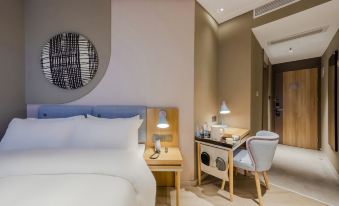 A bedroom with a double bed and desk in the middle, with an open space beside it at Homeinn · neo (Shanghai Nanjing Road Pedestrian Street Huanghe Road)