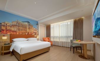 a hotel room with a large bed , a chair , and a window overlooking a cityscape at Vienna Hotel