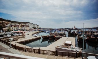 a dock with several boats docked along the waterfront , surrounded by a city skyline in the background at Amble Hotel