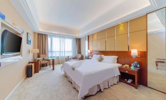 a large hotel room with a king - sized bed in the center , surrounded by various pieces of furniture and decorations at Regency Hotel