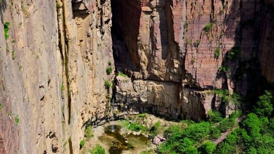 大峡谷两旁绝壁深130多米，如刀劈斧剁，岩石色泽赤红，被称为