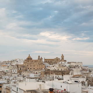 As part of a larger tour I made across Puglia a couple years ago, I had to stop by Ostuni. Ostuni is a unique town that resembles a bright cap rising up right from the flat plains near the southern coast of Italy. Its whitewashed defensive walls and houses in the old town with many winding streets, steps and beautifully decorated, colorful window frames can make you think you're somewhere in Greece.
Also known as “The White City”, because of the white lime tones of its historic center, Ostuni stands on a 600-feet hill overlooking the nearby Adriatic coastline and I must say that Mediterranean vibes ooze from every corner and every alley.
You could definitely spend an entire morning or afternoon wandering around and cherishing the slow life of Apulian people, making pasta or putting laundry out to dry.
Details of its ancient past, baroque and medieval, can be found everywhere across the city in churches and old palaces. Night life is vibrant with tons of places where you can eat, enjoy a gelato or sip a cocktail. #italy #puglia #apulia #roadtrip #italytravel  #italybeauties #mediterranean #awesomepic